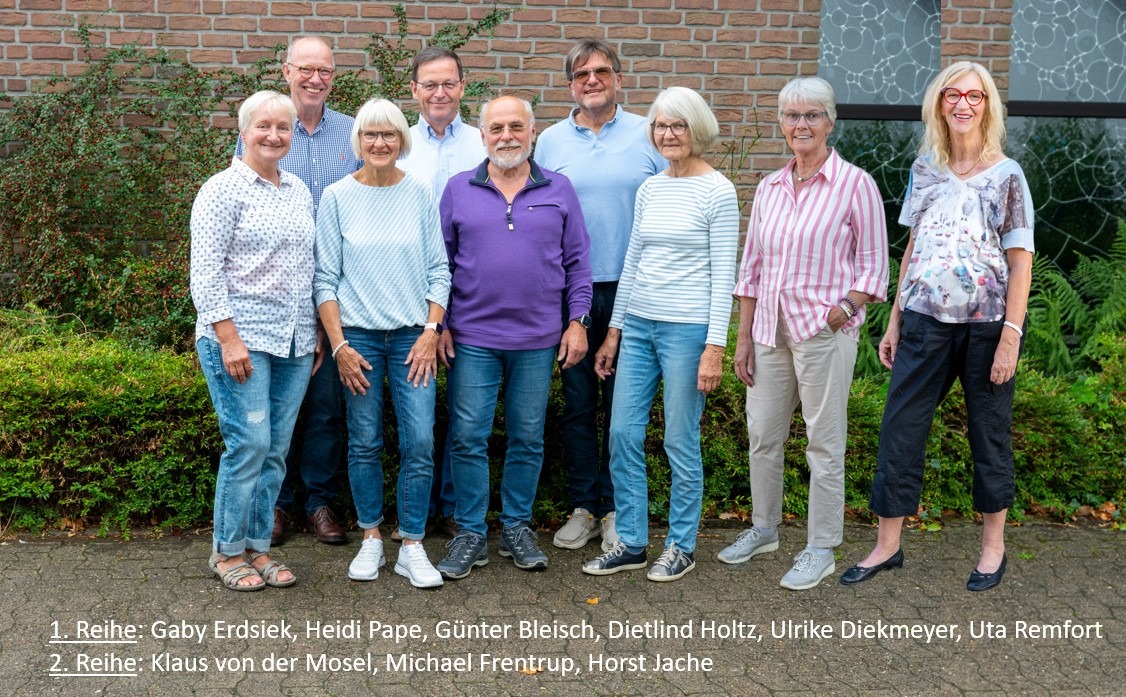 Gruppenporträt von neun Mitarbeitern oder Gemeindemitgliedern; Namen unten aufgeführt.