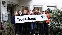 Friedhofsweg mit Bäumen; Logo Evangelischer Friedhof Gütersloh.