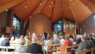 Zwölf Mitglieder des Kirchenvorstands oder Ältestenrates in Kirchenbänken.