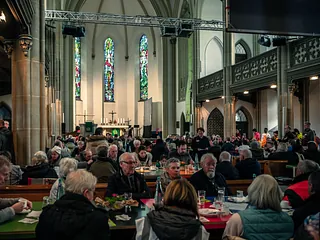 Modernes Kirchengebäude mit Ziegeln, Beton und braunen geometrischen Platten.