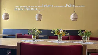 Friedhofsweg mit Bäumen; Logo Evangelischer Friedhof Gütersloh.