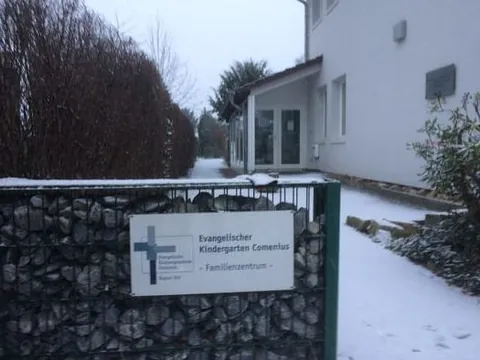 Schild Evangelischer Kindergarten Comenius/Familienzentrum im Schnee.