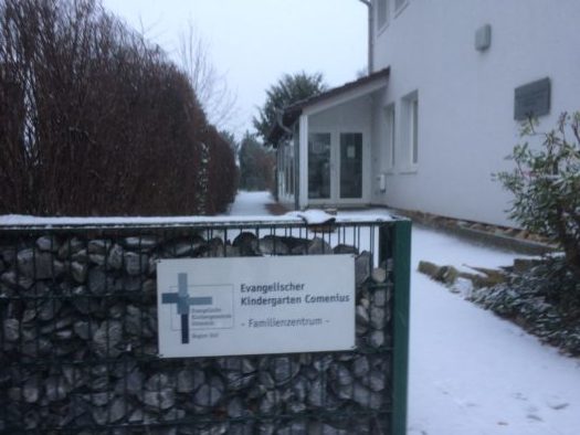 Schild Evangelischer Kindergarten Comenius/Familienzentrum im Schnee.