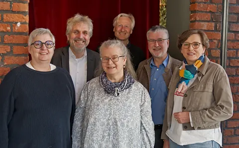 Zwölf Mitglieder des Kirchenvorstands oder Ältestenrates in Kirchenbänken.