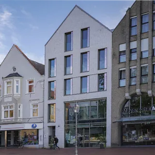 Moderne Backsteinkirchenfassade mit vertikalen Betonsäulen.