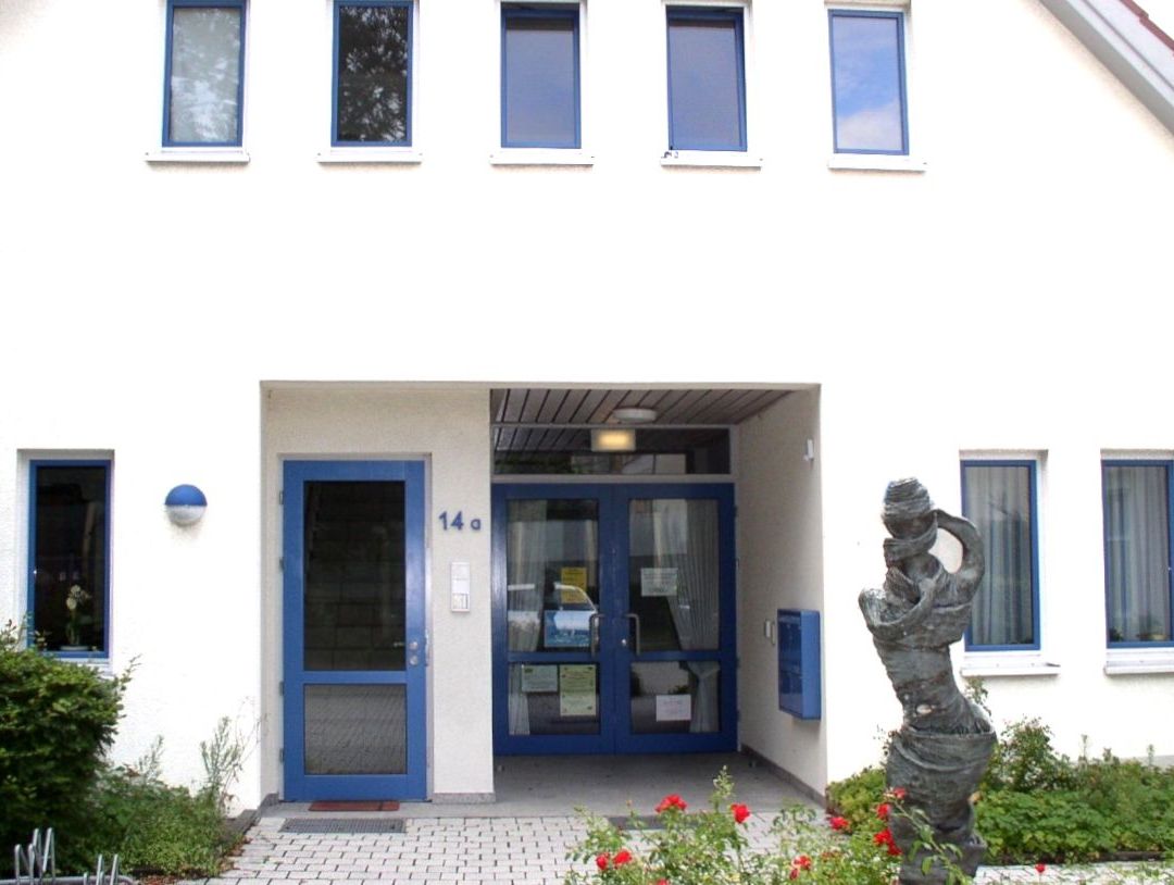 Modernes Kirchengebäude mit Ziegeln, Beton und braunen geometrischen Platten.