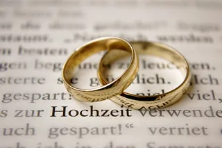 Teelicht brennt in einer Glasvase über kleinen dekorativen Steinen.