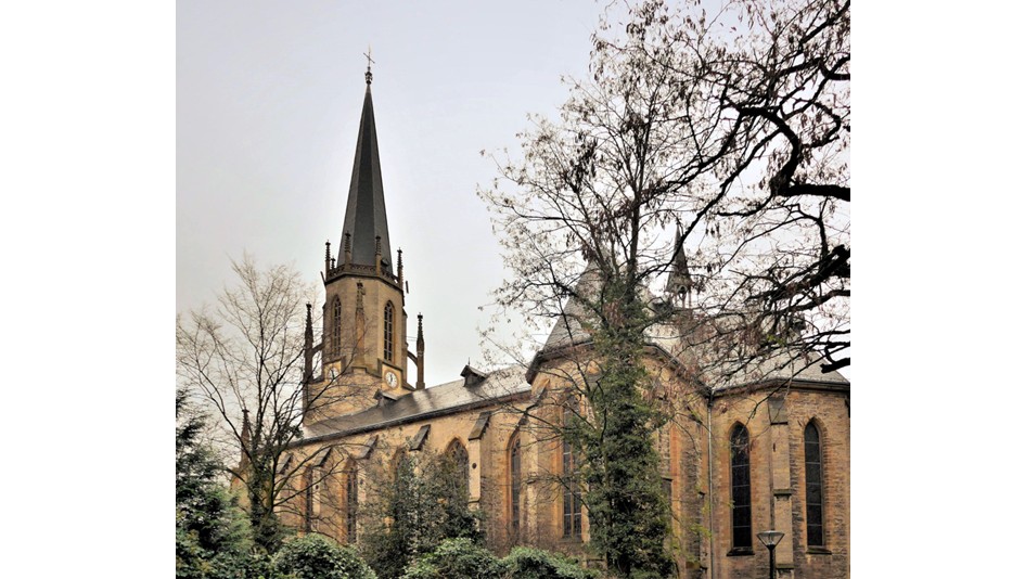 Nahaufnahme von brennenden Votivkerzen in einer Kirche.